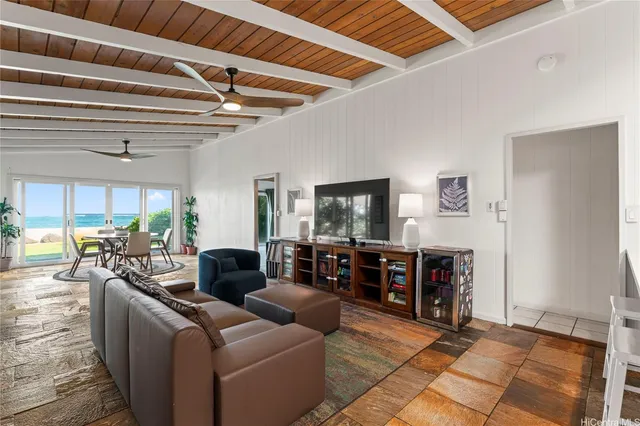 a living room with furniture a flat screen tv and a floor to ceiling window