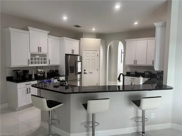 a kitchen with stainless steel appliances kitchen island granite countertop a sink dishwasher and cabinets