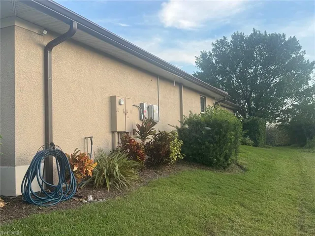 a view of a lake with a yard and large trees
