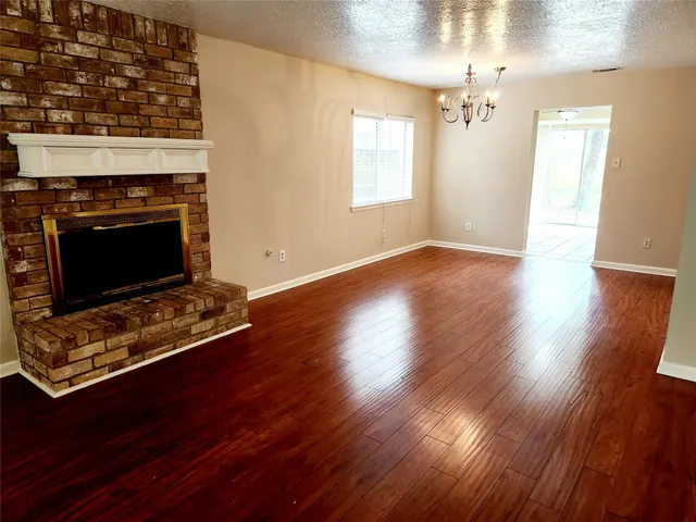 a living room with hard wood floors and a fireplace