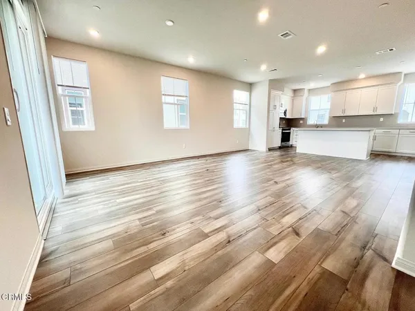 a view of kitchen with kitchen island granite countertop cabinets and wooden floor