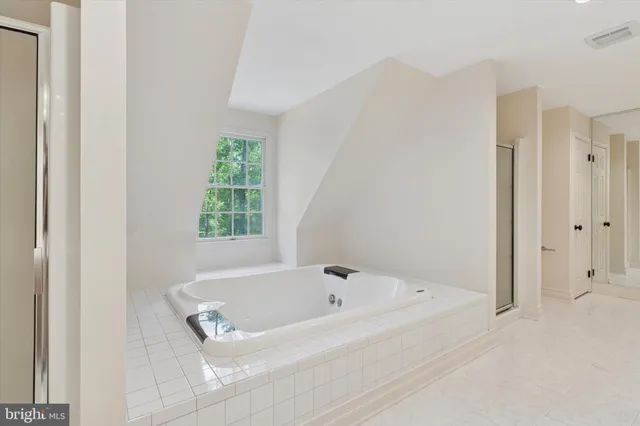 a white bath tub sitting in a bathroom next to a window