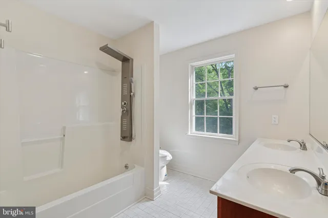 a bathroom with a tub sink and a window