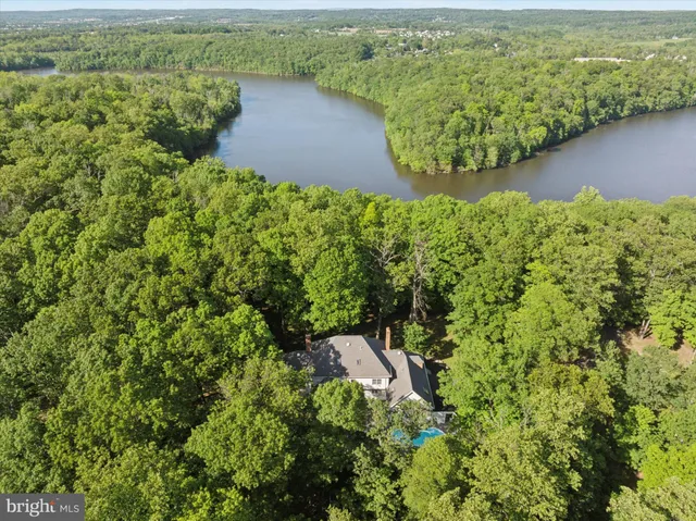 an aerial view of a house with a yard and lake view