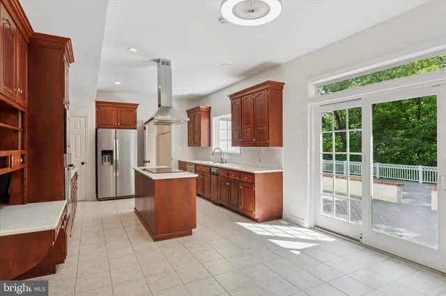 a large kitchen with stainless steel appliances granite countertop a stove a sink dishwasher and a refrigerator with wooden floor