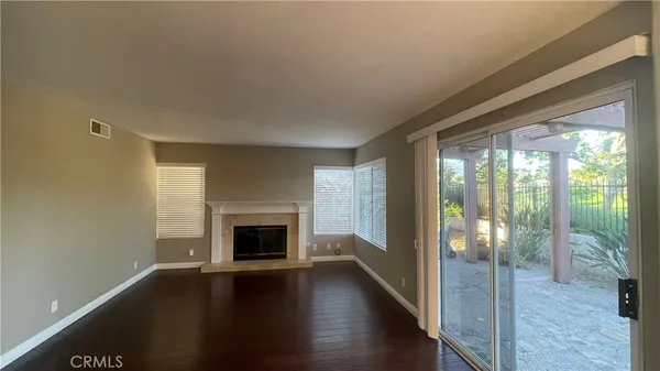 a view of a livingroom with wooden floor fireplace and windows