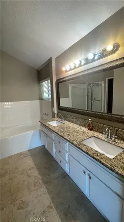 a bathroom with double vanity and a mirror