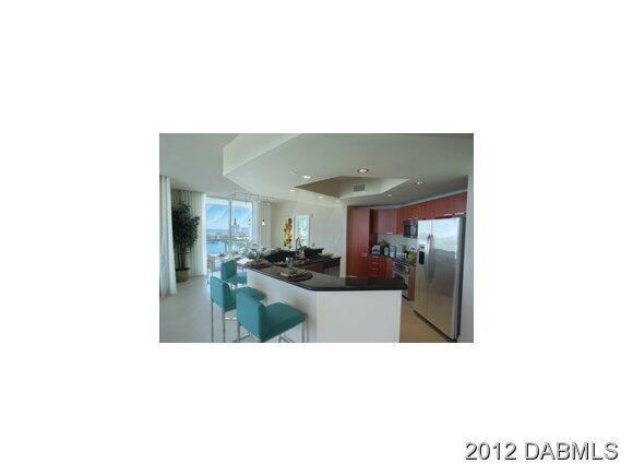 241 Riverside Drive, Unit 905 Holly Hill, FL 32117 - Photo 4 of 8 a open living room with kitchen island and a potted plant