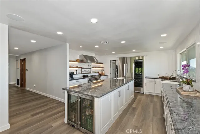 a living room with lots of furniture a chandelier a fireplace and a table