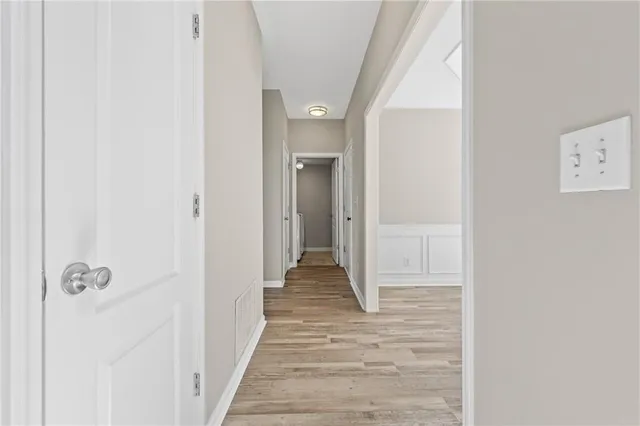 an empty room with windows and chandelier fan