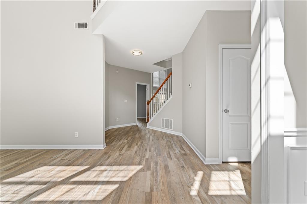 2878 Calhoun Square Suwanee, GA 30024 - Photo 2 of 42 a view of a room with wooden floor and staircase