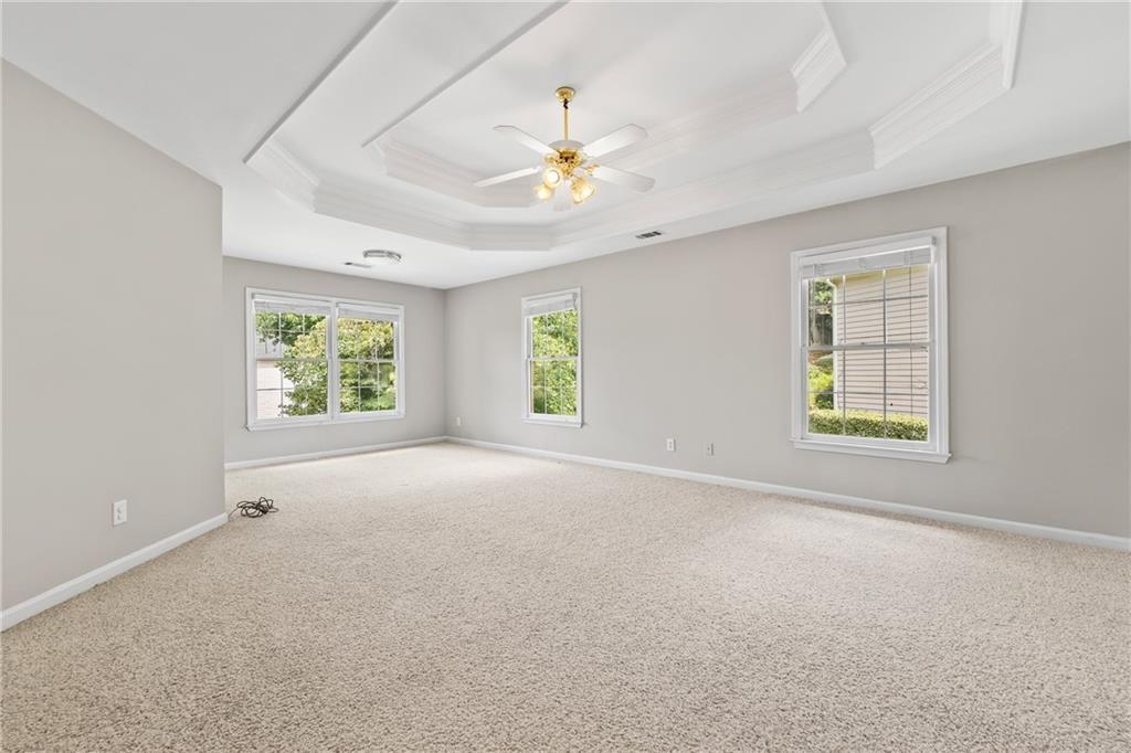 2878 Calhoun Square Suwanee, GA 30024 - Photo 23 of 42 an empty room with windows and chandelier fan