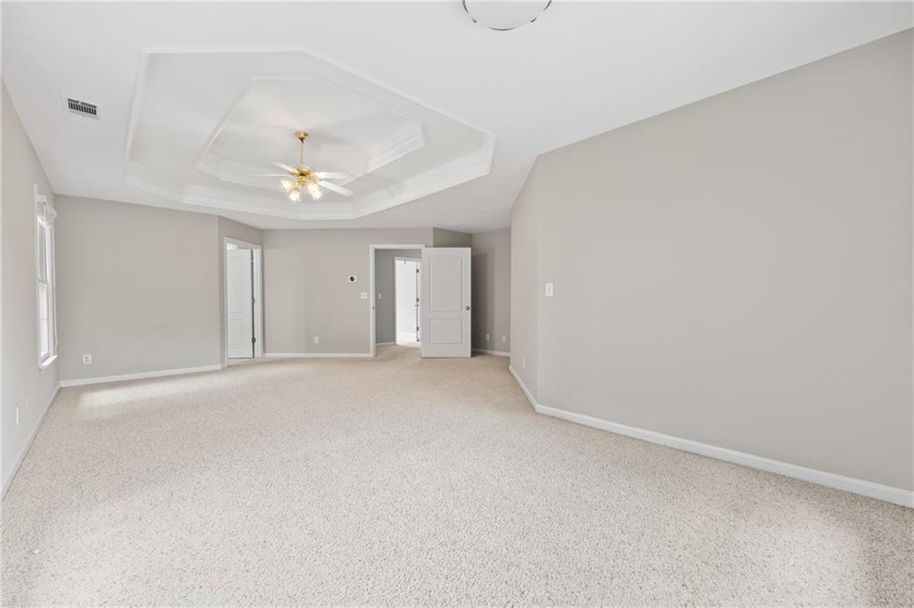 2878 Calhoun Square Suwanee, GA 30024 - Photo 25 of 42 a view of an empty room with a chandelier fan