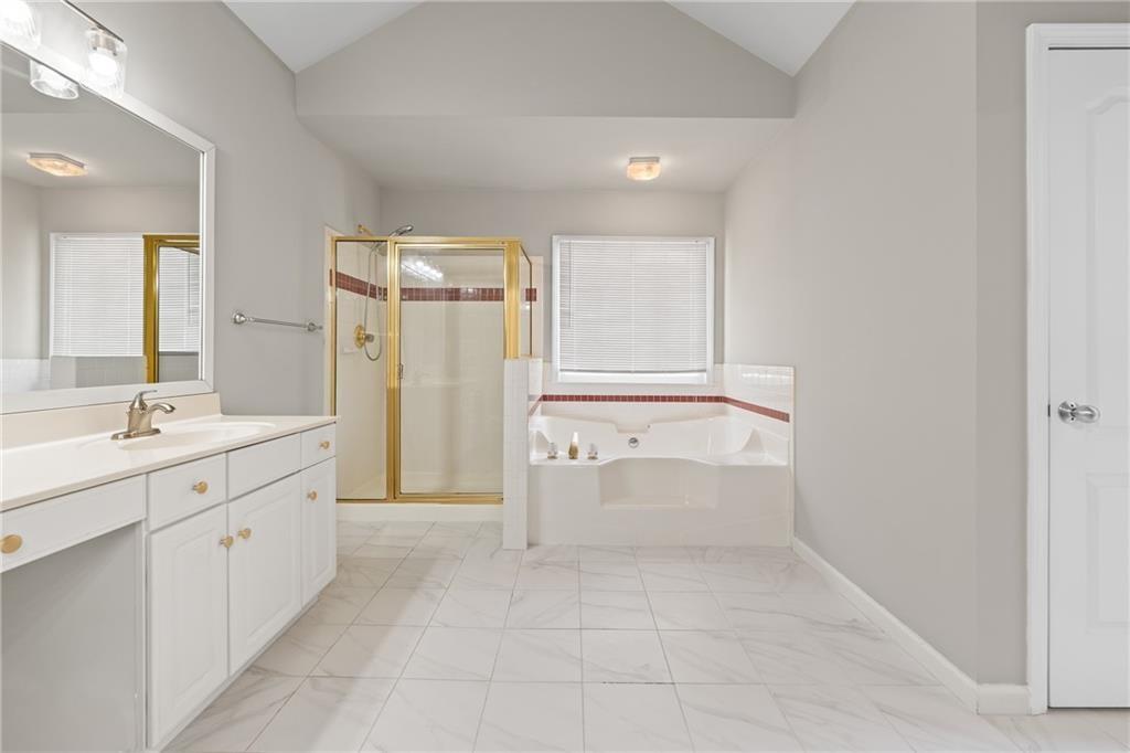 2878 Calhoun Square Suwanee, GA 30024 - Photo 27 of 42 a bathroom with a granite countertop sink mirror and a bathtub