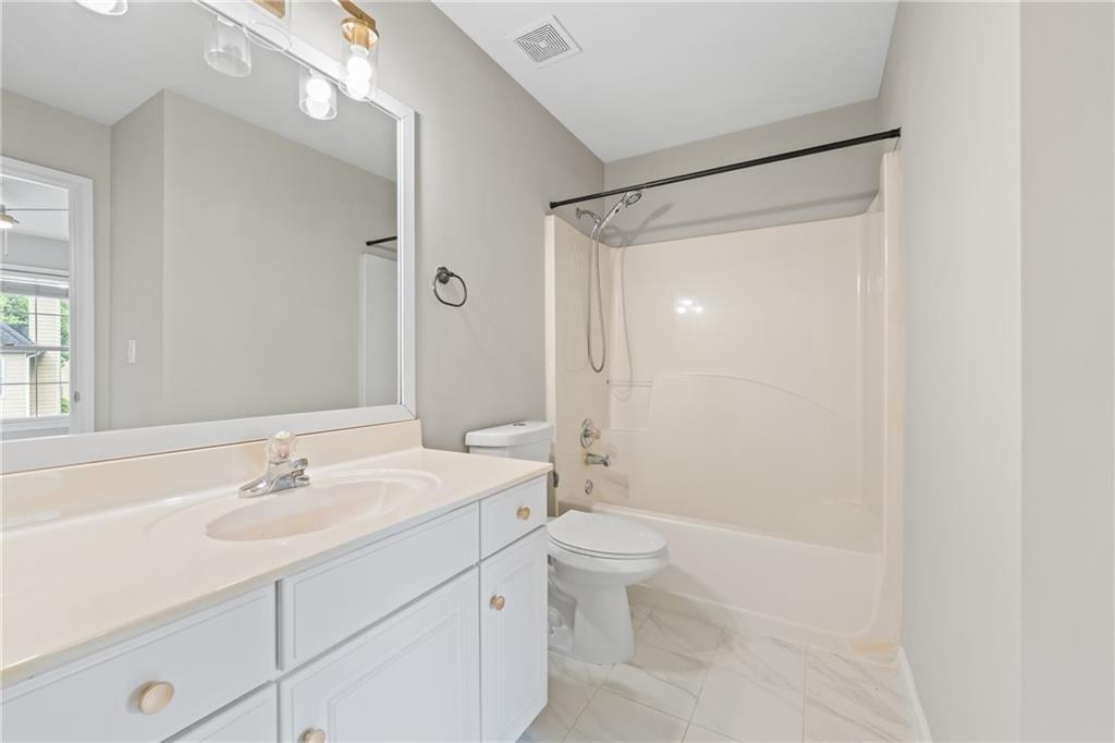 2878 Calhoun Square Suwanee, GA 30024 - Photo 34 of 42 a bathroom with a sink a toilet a shower and a mirror