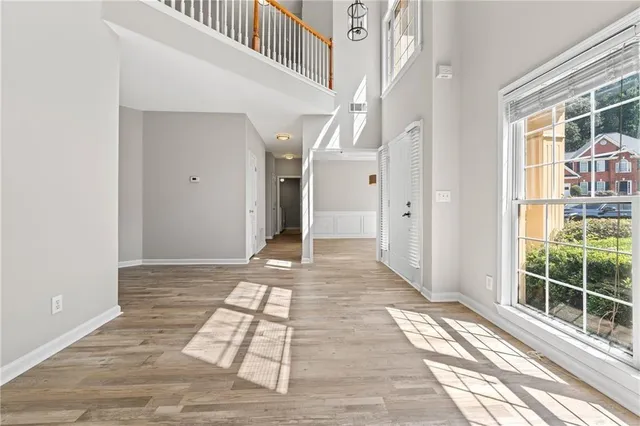 an empty room with wooden floor and windows