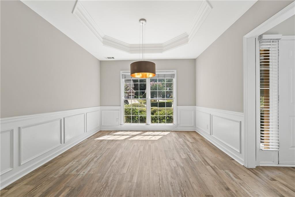2878 Calhoun Square Suwanee, GA 30024 - Photo 7 of 42 a view of an empty room with a window and wooden floor