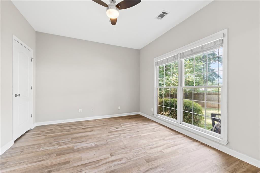 2878 Calhoun Square Suwanee, GA 30024 - Photo 9 of 42 a view of an empty room with wooden floor and a window
