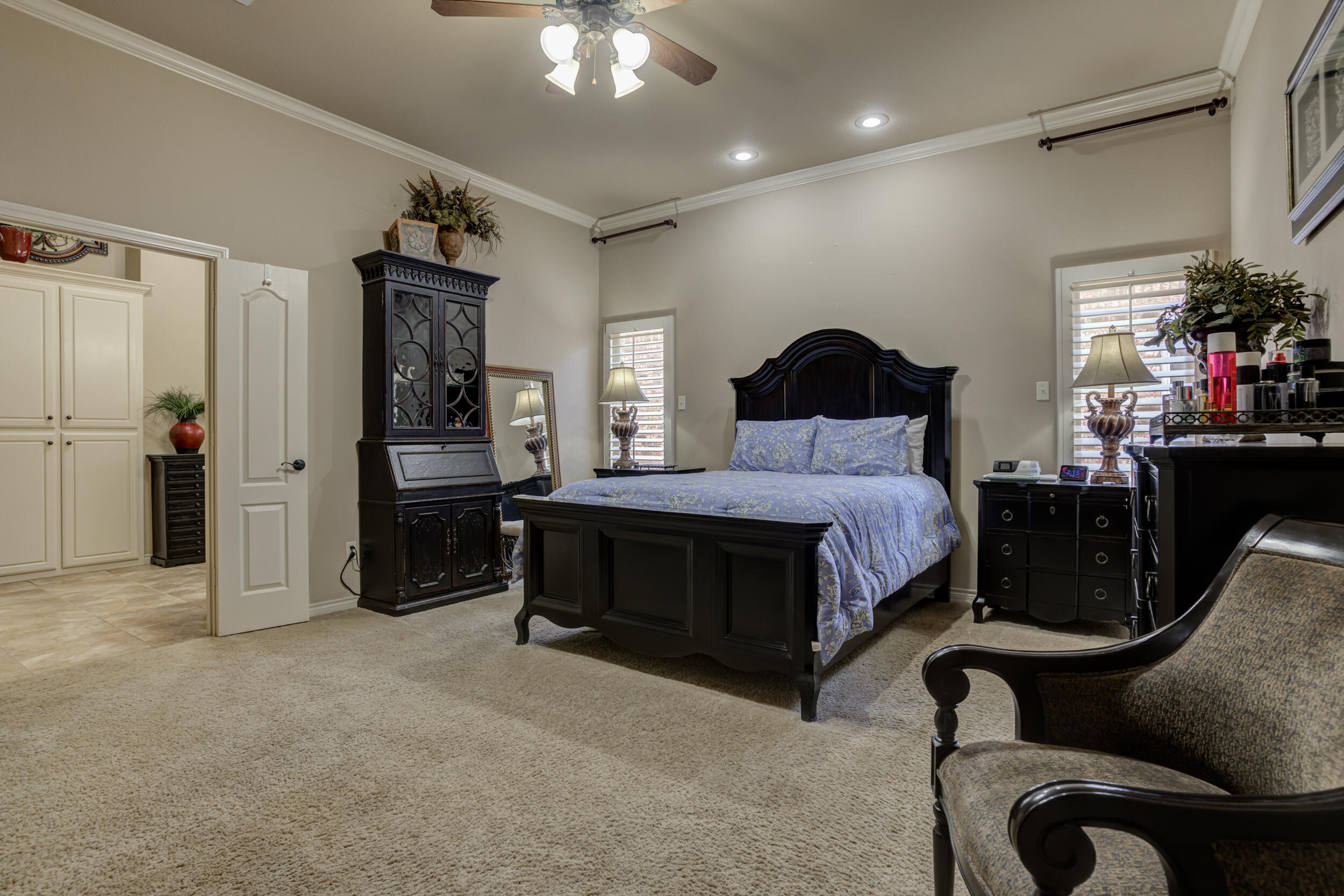 6008 89th Street Lubbock, TX 79424 - Photo 26 of 61 a spacious bedroom with a bed and a chandelier