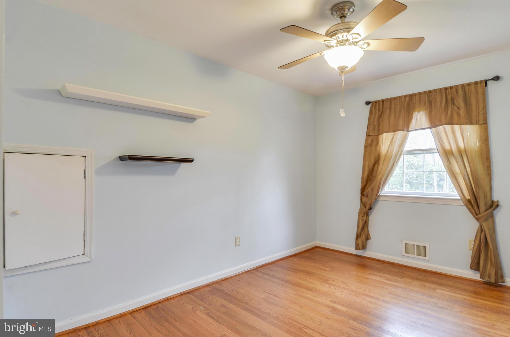 1395 Kimblewick Road Potomac, MD 20854 - Photo 21 of 30 an empty room with wooden floor fan and windows