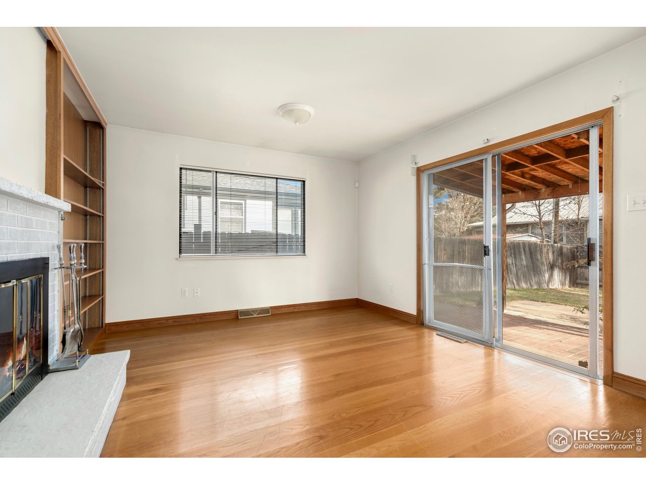 409 7th Street Windsor, CO 80550 - Photo 14 of 42 a view of an empty room with a window and wooden floor