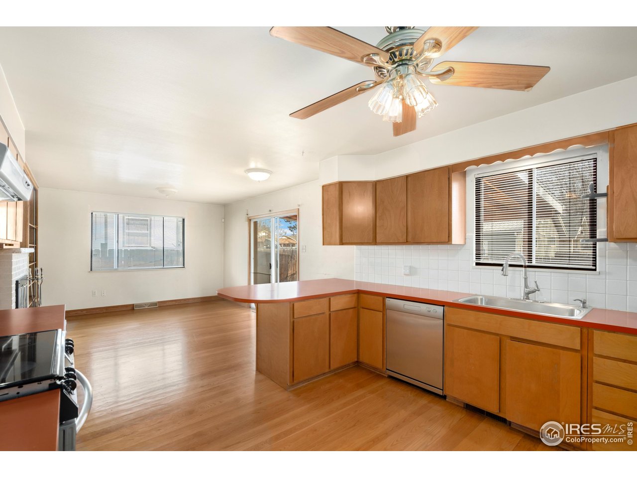 409 7th Street Windsor, CO 80550 - Photo 16 of 42 a kitchen with stainless steel appliances granite countertop a sink cabinets and wooden floor