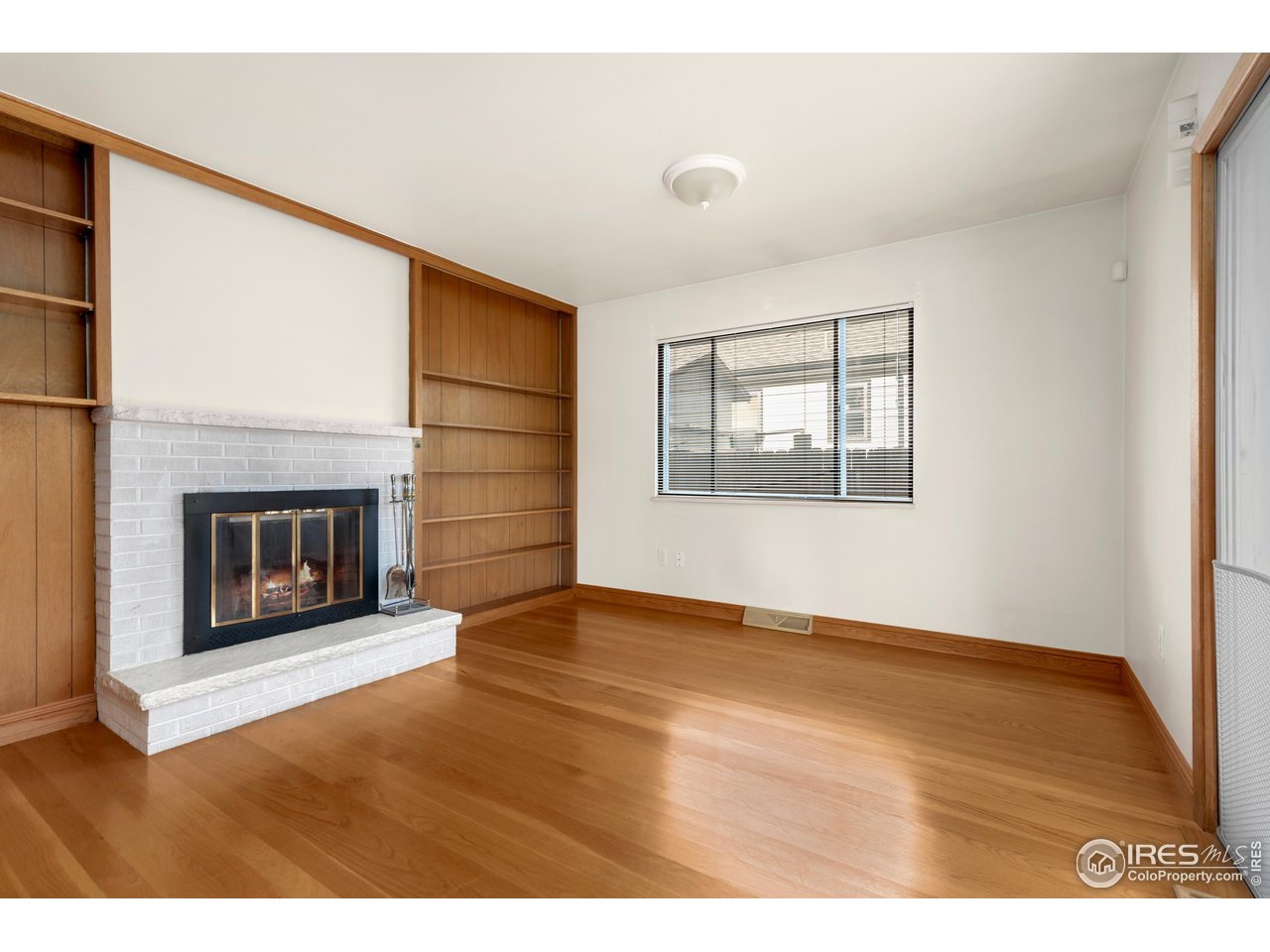 409 7th Street Windsor, CO 80550 - Photo 18 of 42 a view of an empty room with a fireplace and a window