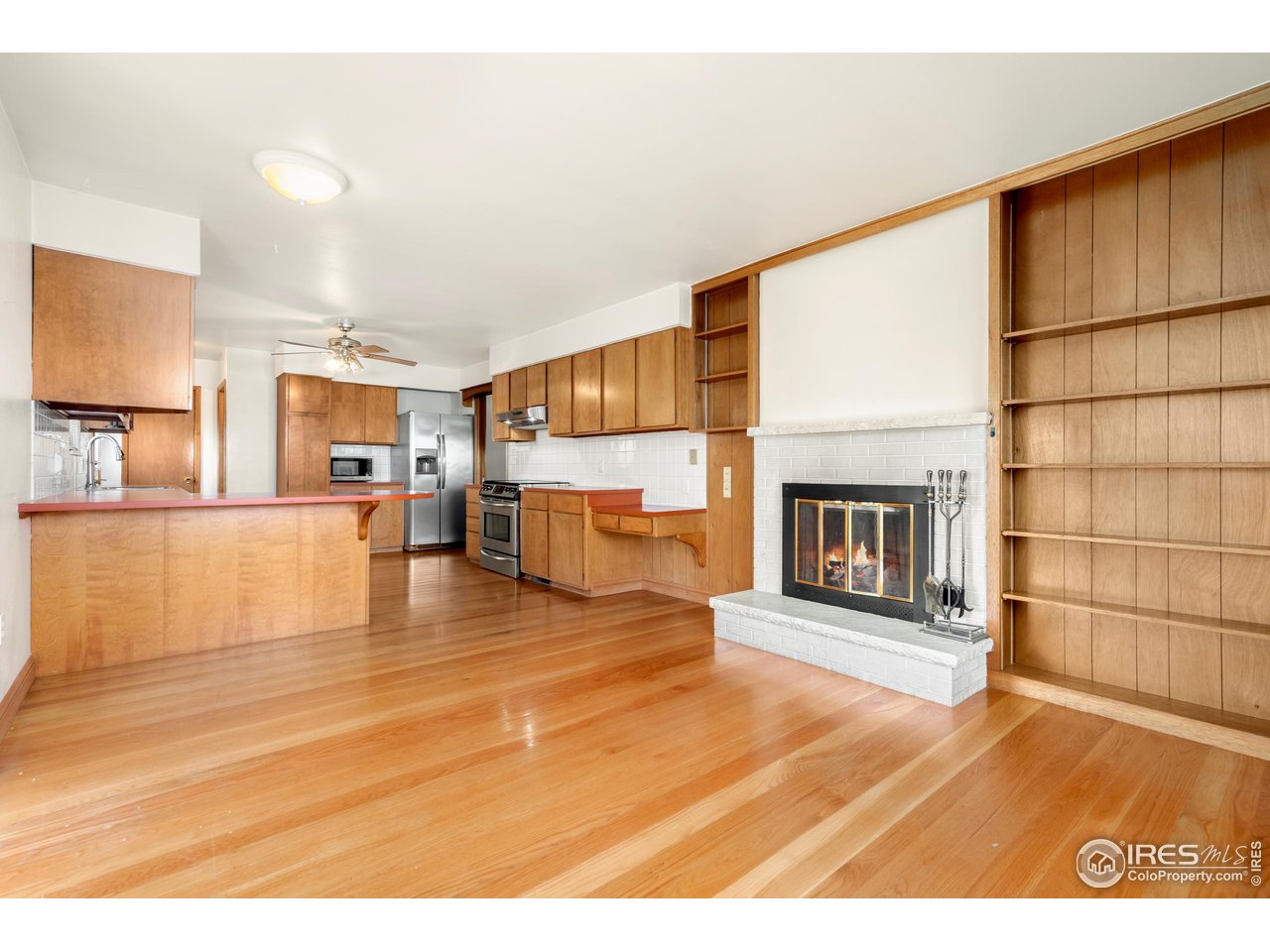 409 7th Street Windsor, CO 80550 - Photo 10 of 42 a view of a living room kitchen with a fireplace