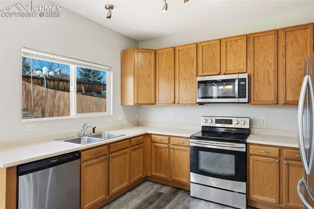 a kitchen with stainless steel appliances granite countertop white cabinets a sink and a stove