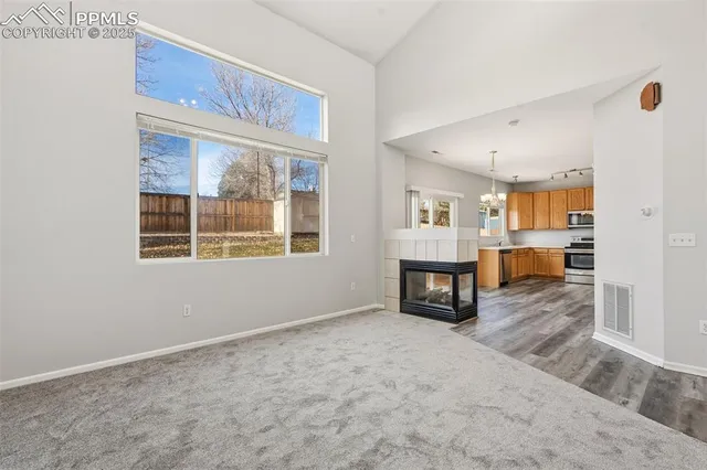 a view of an empty room with a fireplace and a window