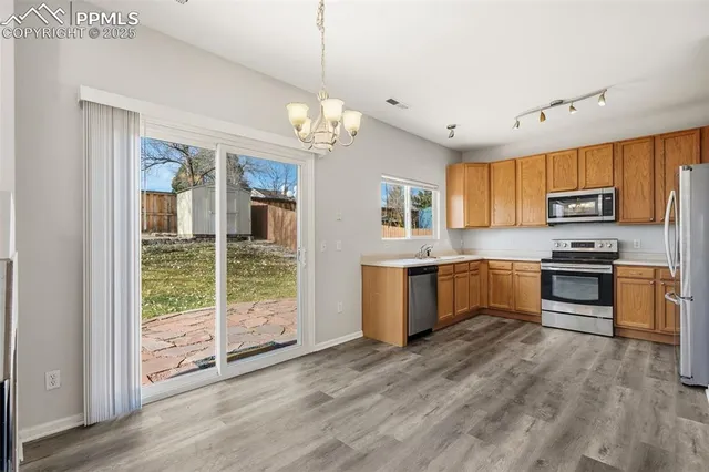 a large kitchen with a window and stainless steel appliances