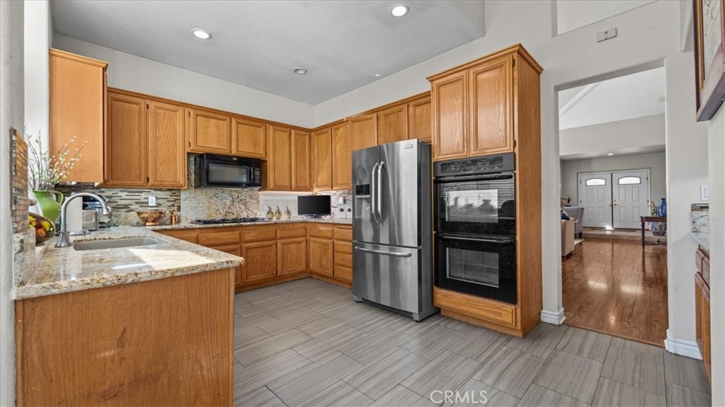 1671 Dominguez Ranch Road Corona, CA 92878 - Photo 16 of 42 a kitchen with a refrigerator a sink and a stove