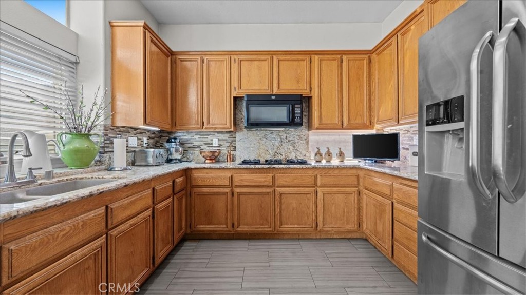 1671 Dominguez Ranch Road Corona, CA 92878 - Photo 17 of 42 a kitchen with stainless steel appliances granite countertop a refrigerator and cabinets