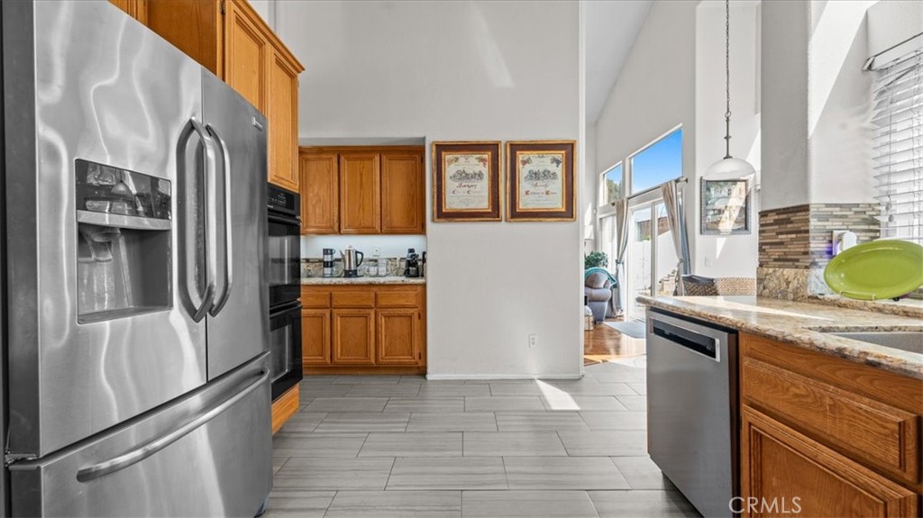1671 Dominguez Ranch Road Corona, CA 92878 - Photo 18 of 42 a kitchen with stainless steel appliances granite countertop a refrigerator a stove and a sink with large cabinets