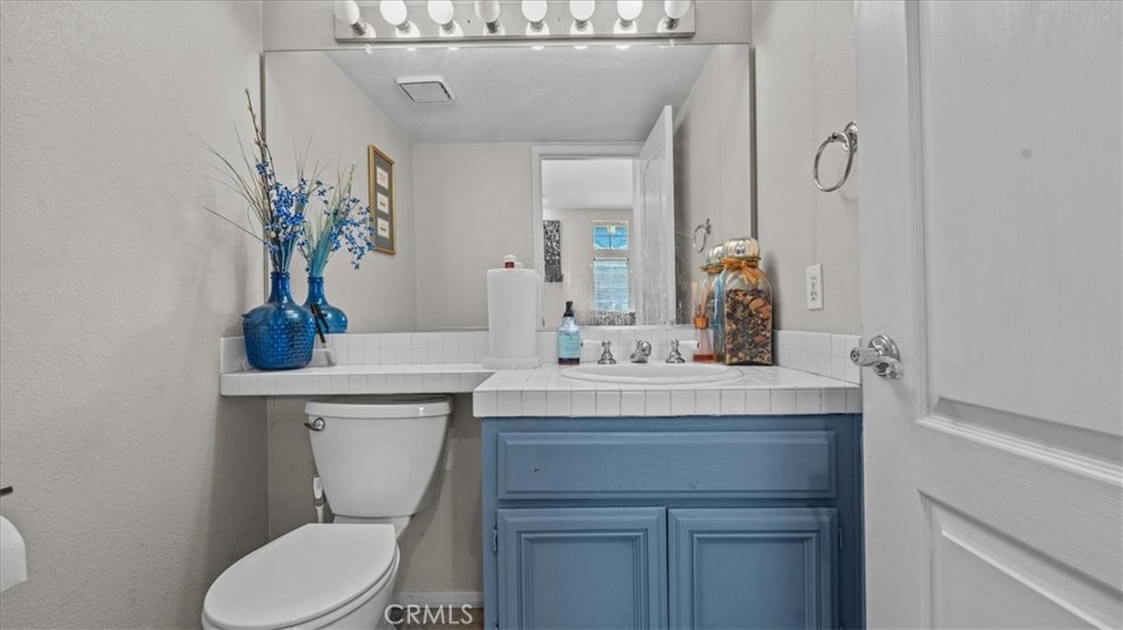 1671 Dominguez Ranch Road Corona, CA 92878 - Photo 23 of 42 a bathroom with a toilet sink and mirror