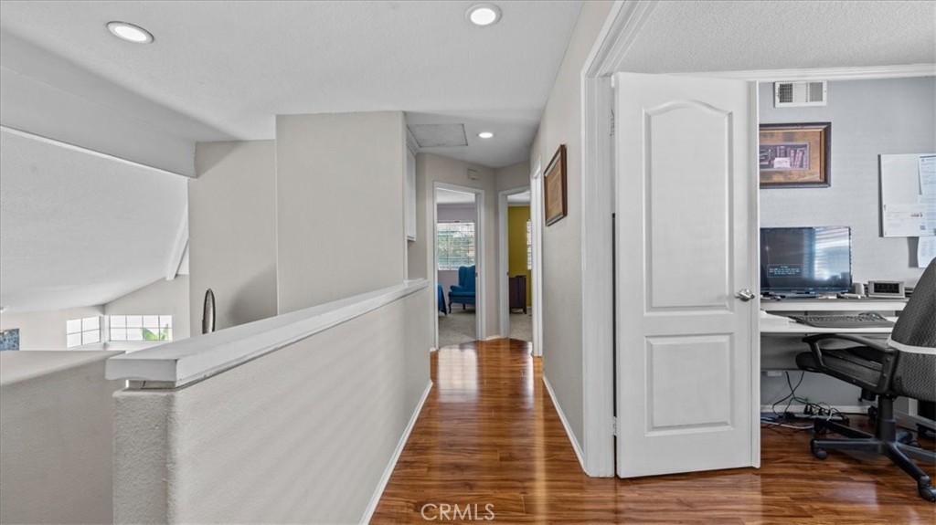 1671 Dominguez Ranch Road Corona, CA 92878 - Photo 25 of 42 a view of a hallway with workspace and wooden floor