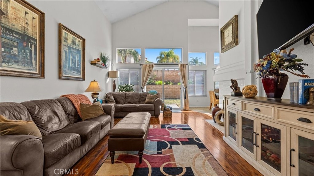1671 Dominguez Ranch Road Corona, CA 92878 - Photo 5 of 42 a living room with furniture a flat screen tv and a floor to ceiling window