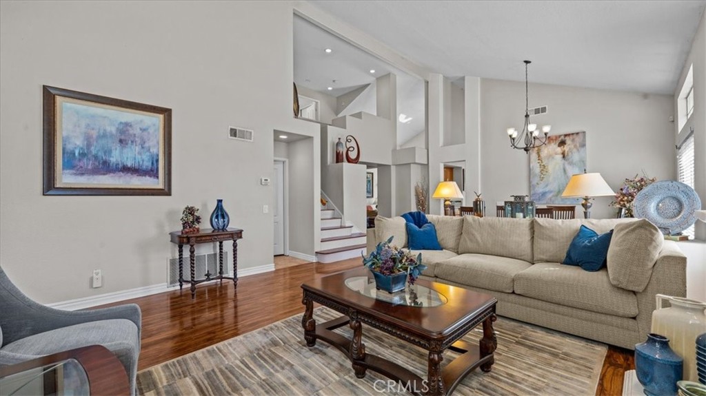 1671 Dominguez Ranch Road Corona, CA 92878 - Photo 9 of 42 a living room with furniture a dining table and a chandelier