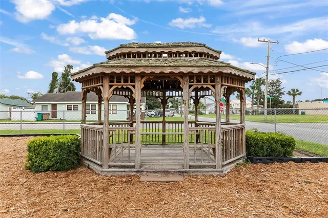 a view of a house with a big yard and large tree