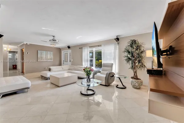 a living room with patio furniture and a flat screen tv