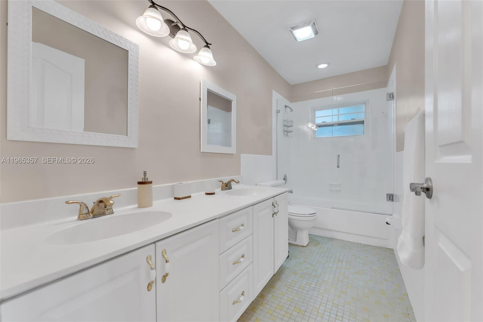 11201 Southwest 136th Street Miami, FL 33176 - Photo 19 of 40 a bathroom with a double vanity sink toilet mirror and bathtub