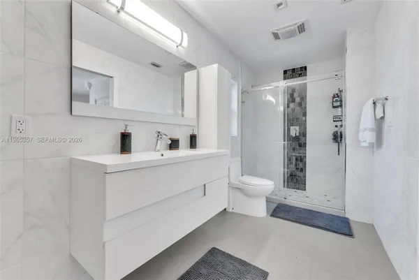a bathroom with a toilet sink a shower and a mirror