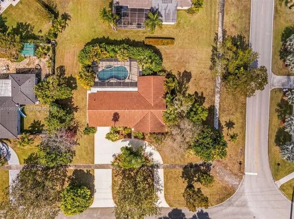 aerial view of a house with a yard and lake view