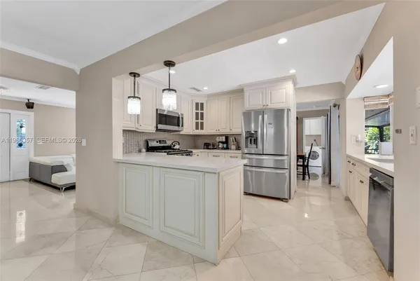 a kitchen with stainless steel appliances a refrigerator sink and stove