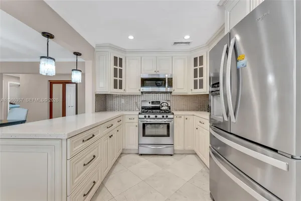 a kitchen with white cabinets and stainless steel appliances