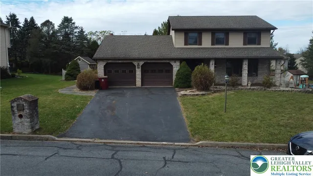 a front view of a house with a yard and trees