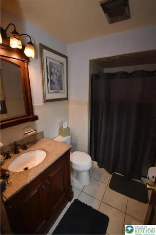 a bathroom with a granite countertop toilet sink and mirror