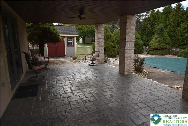 a view of a patio with table and chairs a barbeque with wooden fence