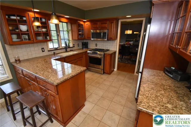 a kitchen with granite countertop a stove a sink and a refrigerator