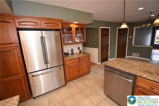 a kitchen with stainless steel appliances granite countertop a refrigerator a sink and a stove
